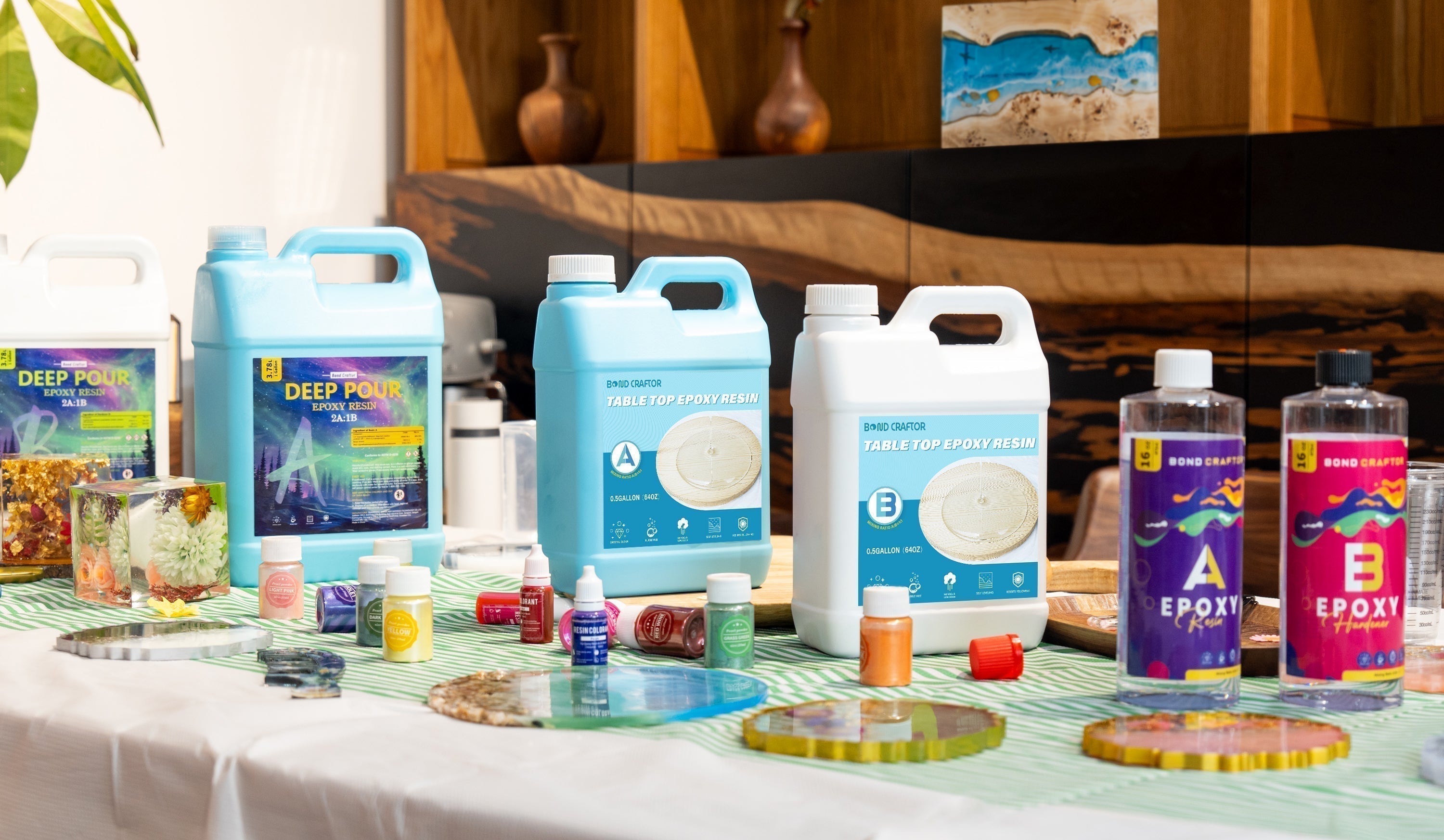 A workspace showcases table top epoxy resin (center, labeled "TABLE TOP EPOXY RESIN") alongside other epoxy types (e.g., "DEEP POUR" on the left), paired with pigments and finished resin art, visually highlighting their differences.